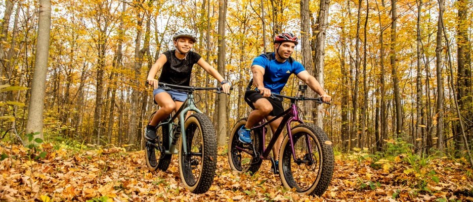 A boy and his father riding bikes through the forest