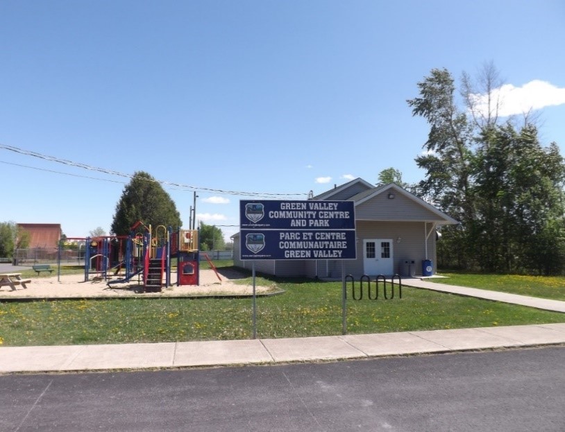 This image depicts an entrance view of the Green Valley Community Centre and park play structure